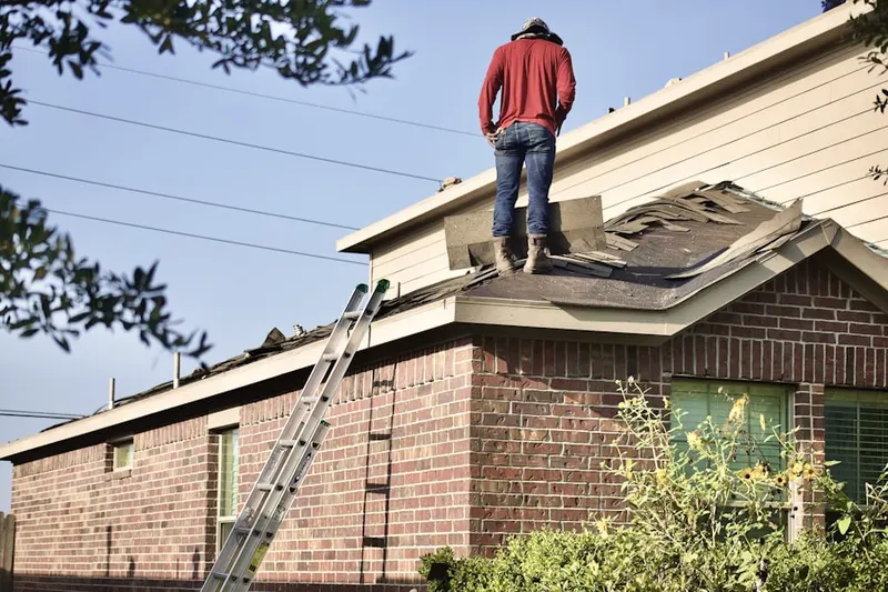 Professional roofer working on a residential roof in Coast Village